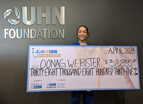 50/50 Raffle Winner holding large cheque